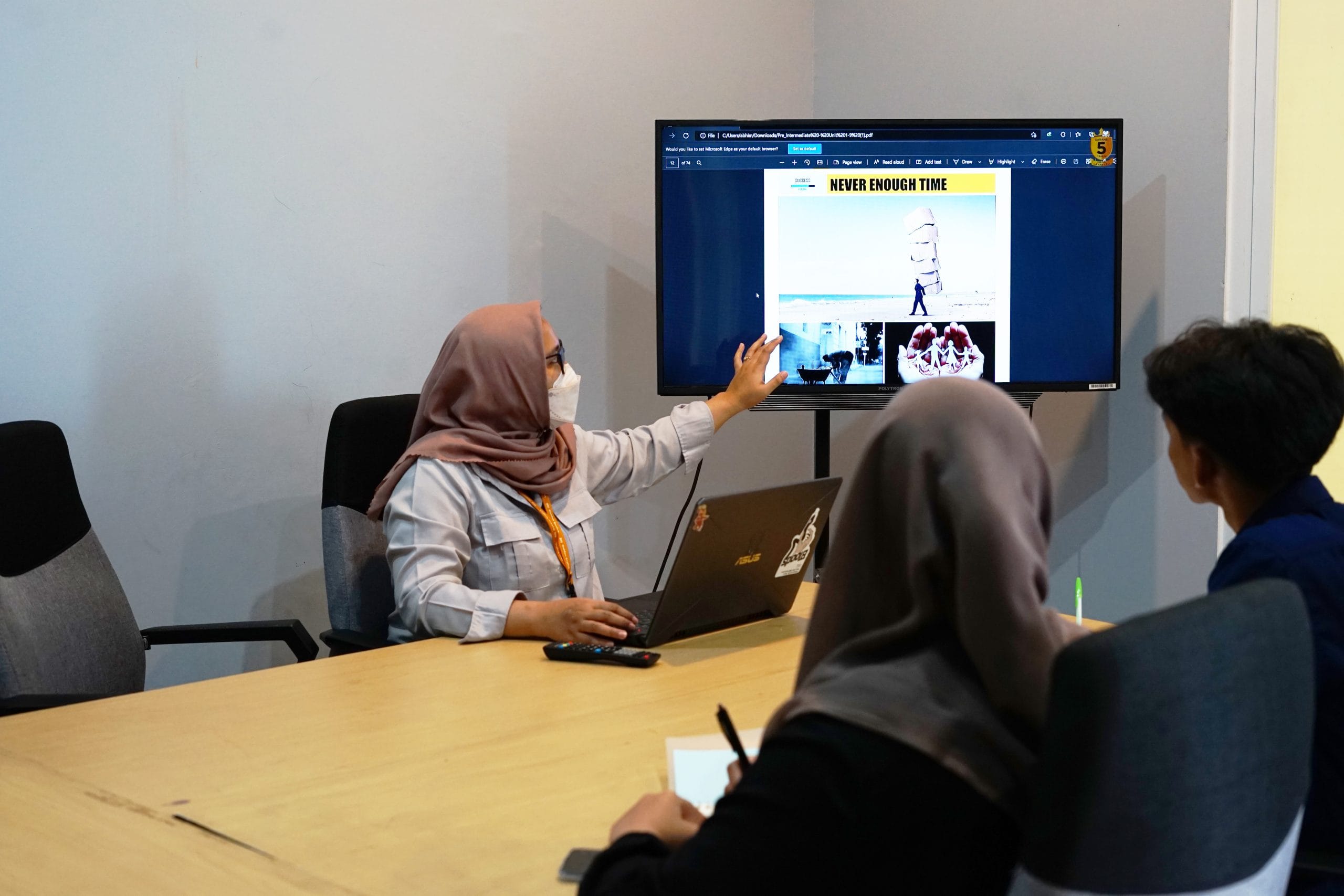 Seorang mahasiswa bimbingan study abroad melihat layar laptop dengan ekspresi gembira dan puas saat menerima surat penerimaan universitas