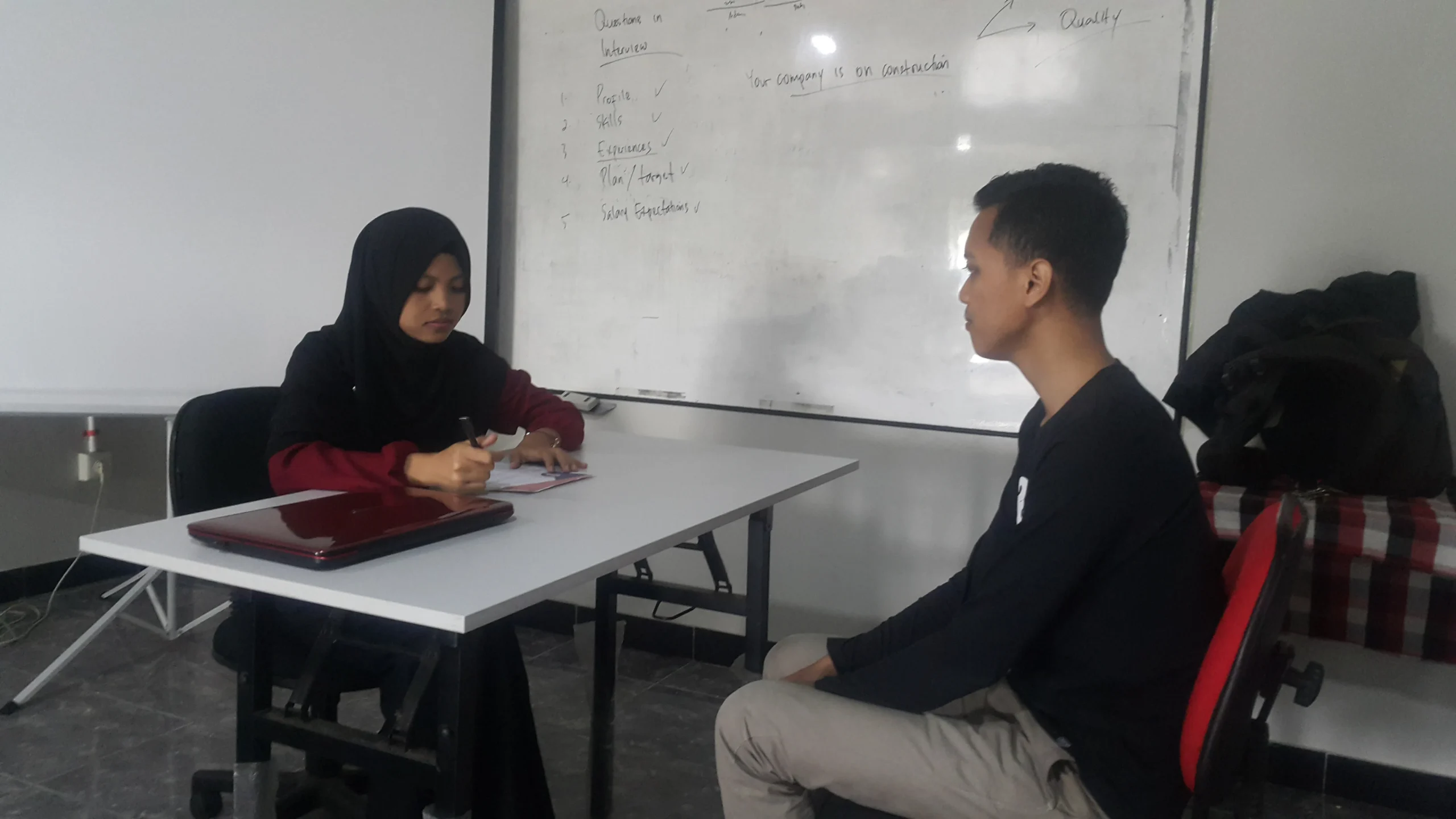 Sesi belajar privat satu lawan satu antara mentor dan murid di depan laptop dengan suasana fokus dan suportif