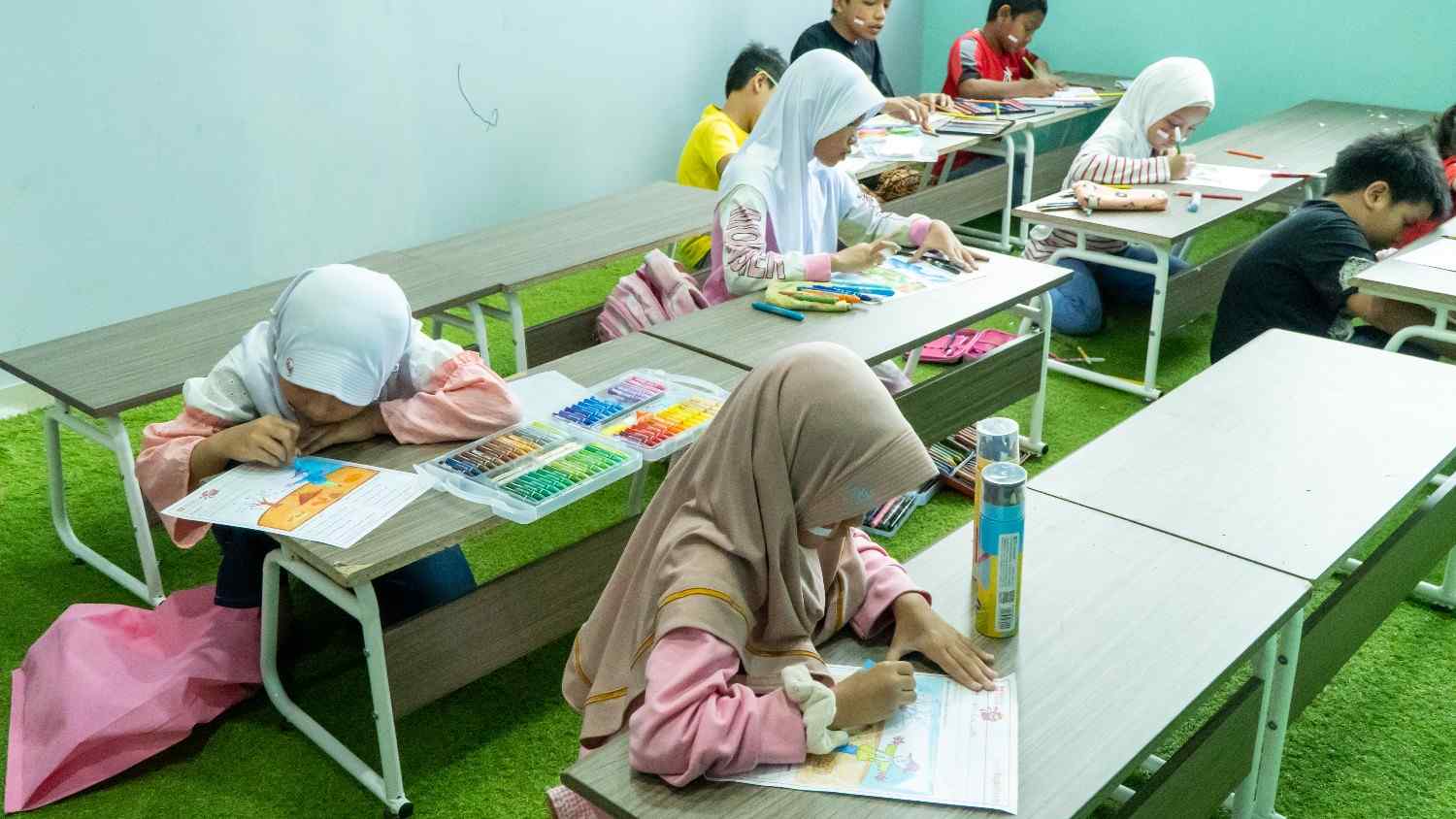 Seorang anak perempuan tersenyum menunjukkan lembar gambar sketsa ke depan kamera laptop
