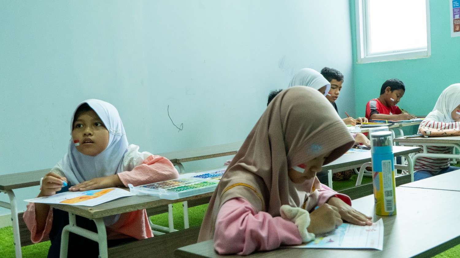 Anak menunjukkan hasil karya lukisan kreatif buatannya sendiri dengan wajah bahagia