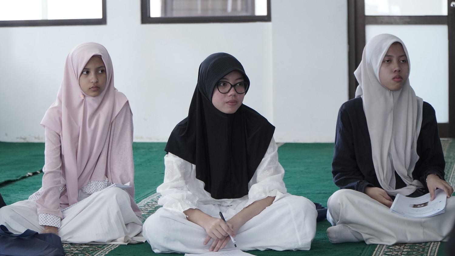 Seorang muslim sedang membaca Al-Quran dengan khusyuk dalam sesi les privat bahasa arab Creya Edu