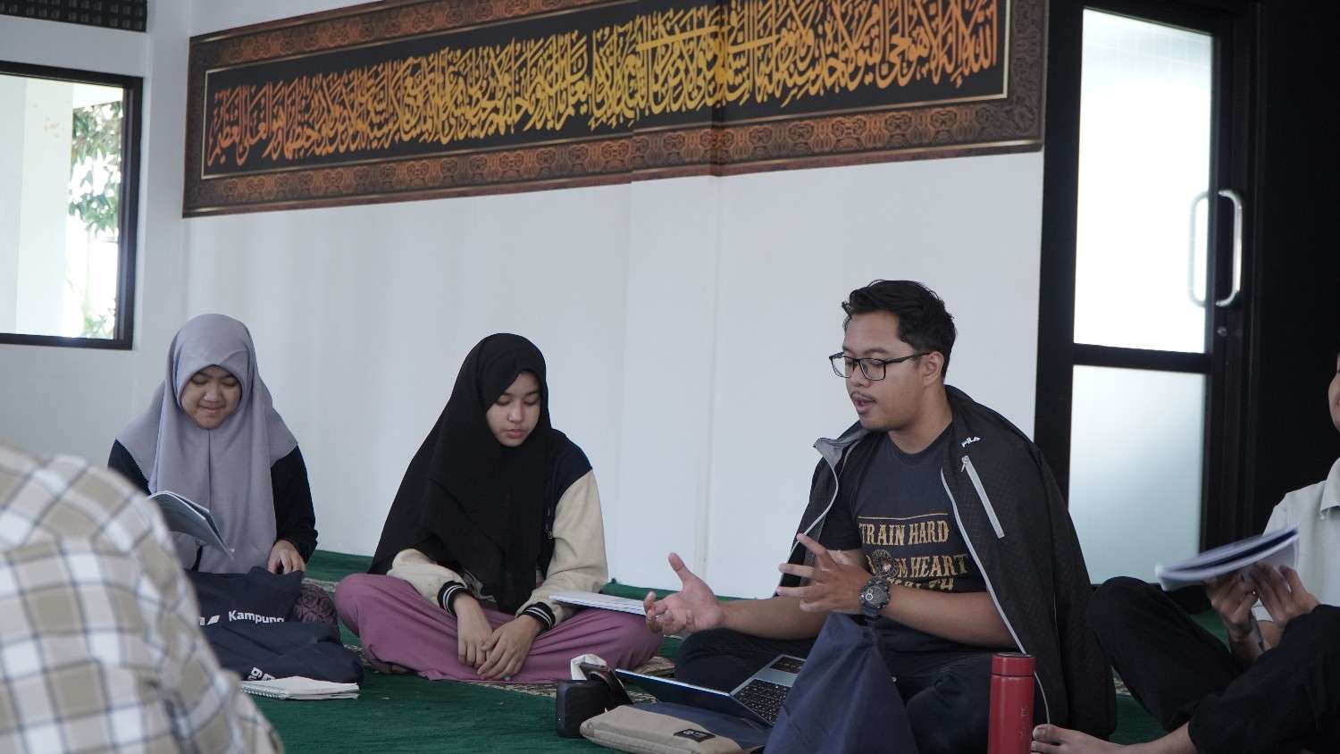 Anak belajar menulis huruf Arab bersama guru